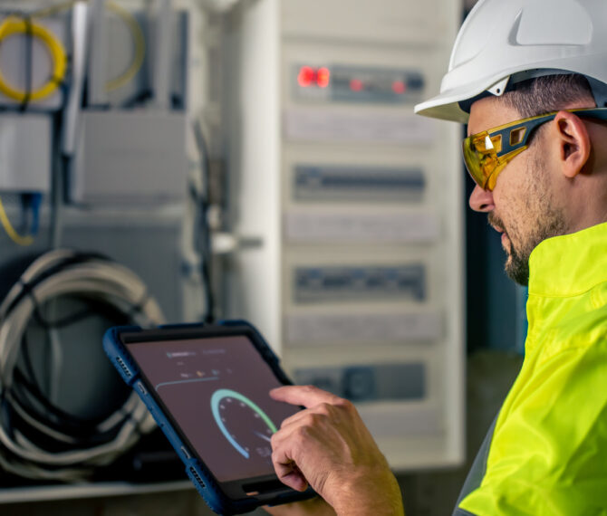 Man, an electrical technician working in a switchboard with fuses. Installation and connection of electrical equipment.